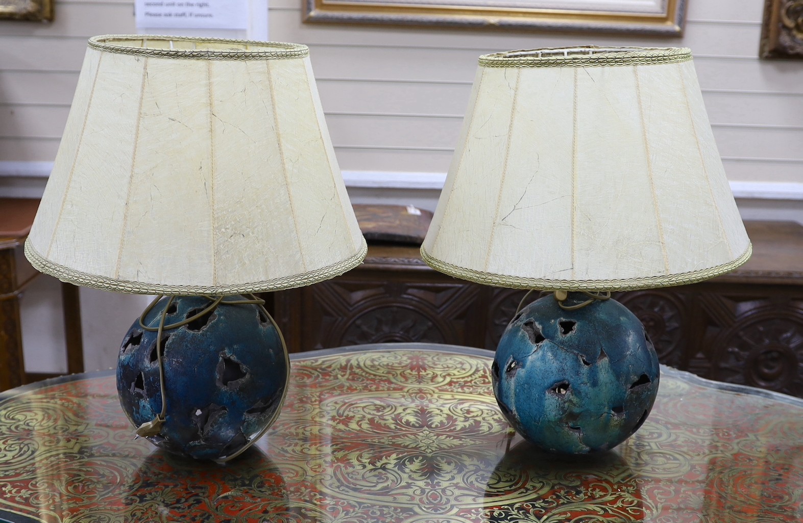A pair of pierced pottery table lamps with vellum shades, 28cm